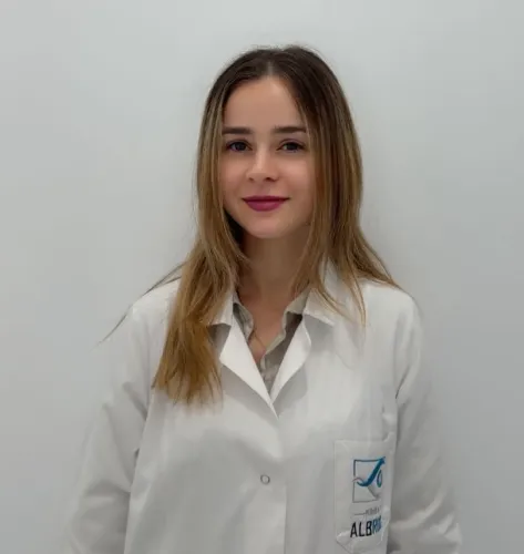 Nurse in uniform posing in front of a white wall