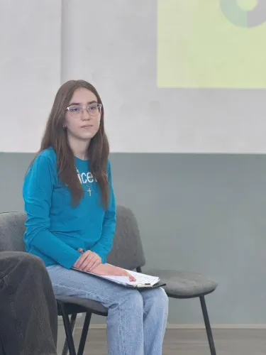 amelia standing on a chair holding a notebook in her hands