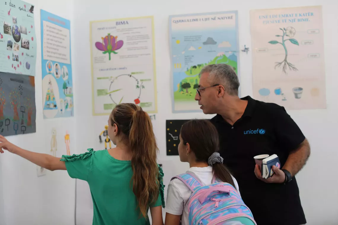 Two pupils showing UNICEF Rep. around their school