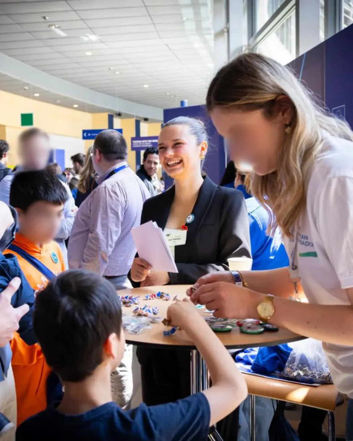 girl smiling in a conference surrounded by people in the background