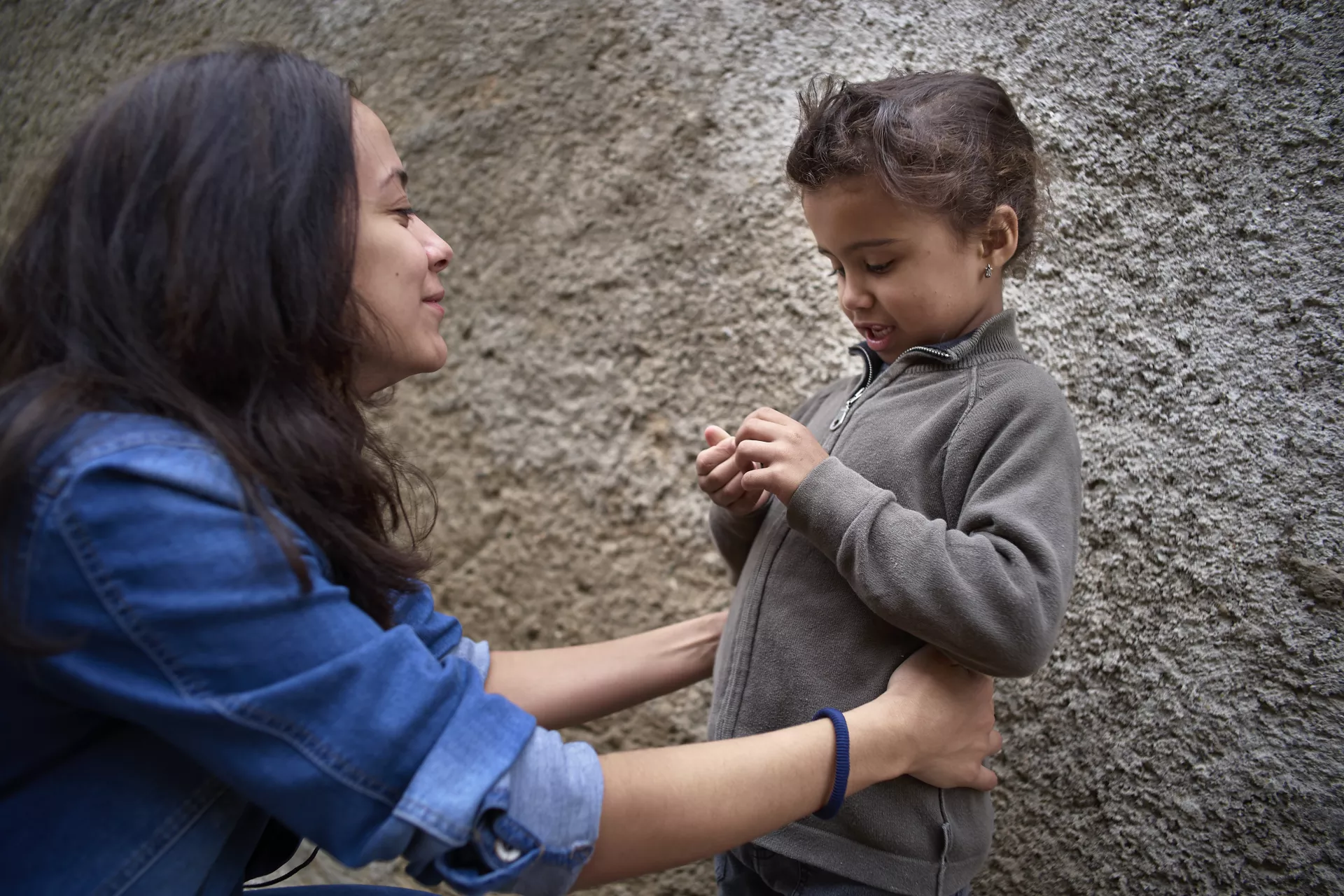 Une jeune femme qui essaye d'embrasser un petite fille
