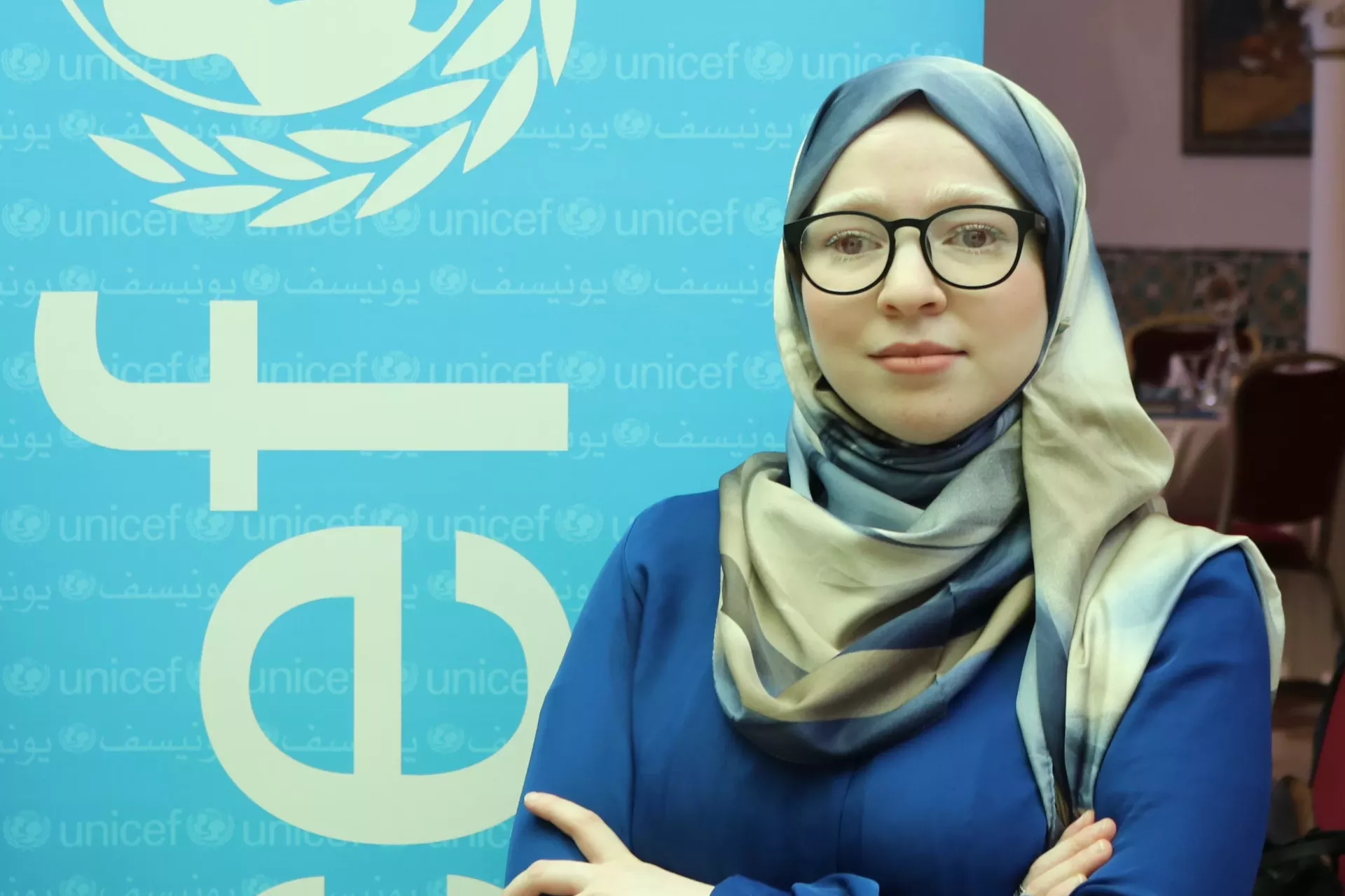 A young girl beside UNICEF flag