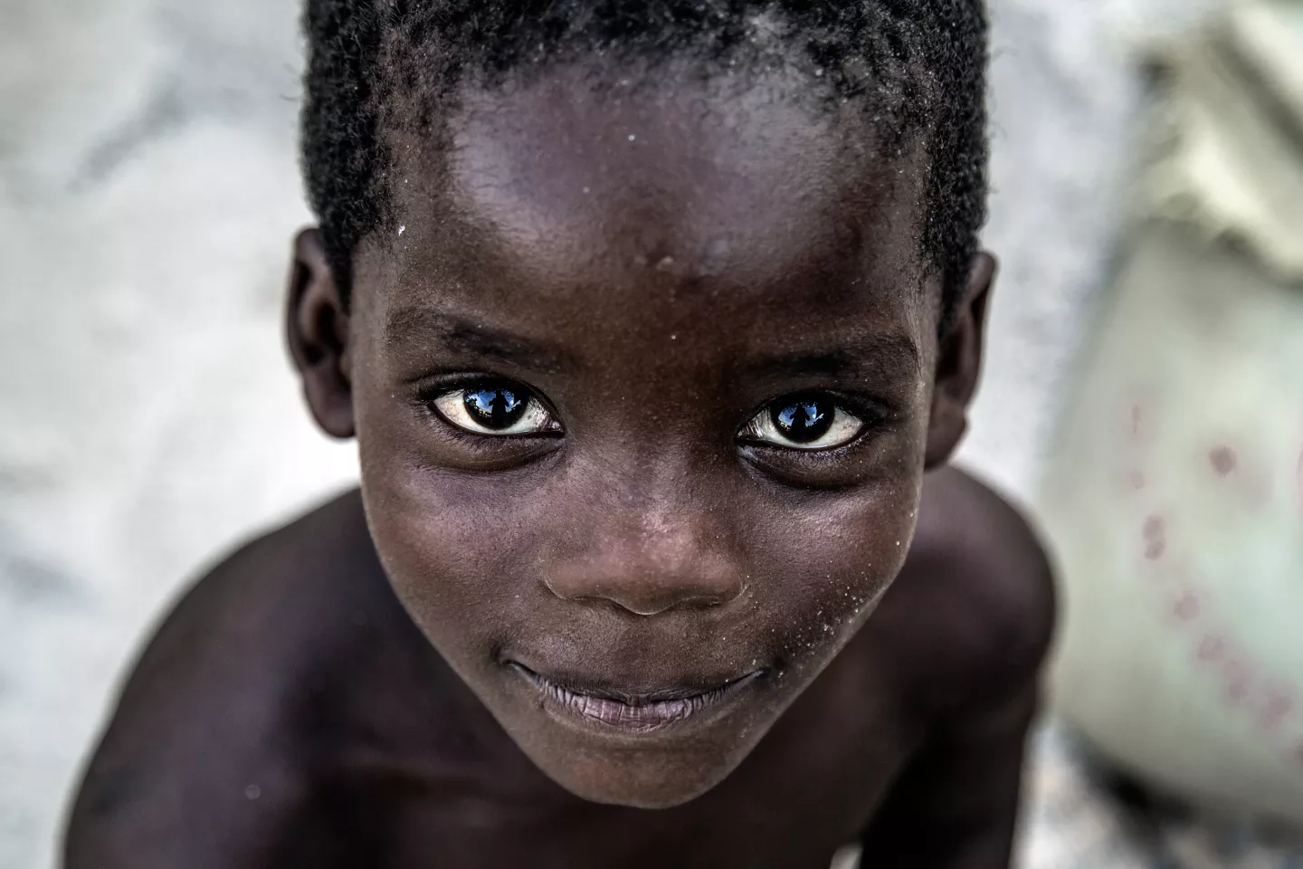 Boys looks to the camera in close up, in Angola