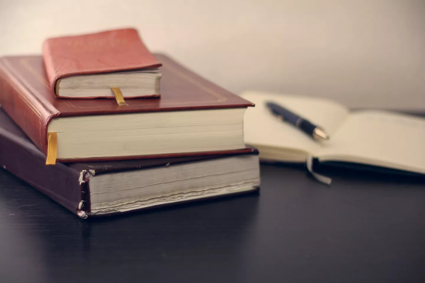 Books and a notepad with a pen