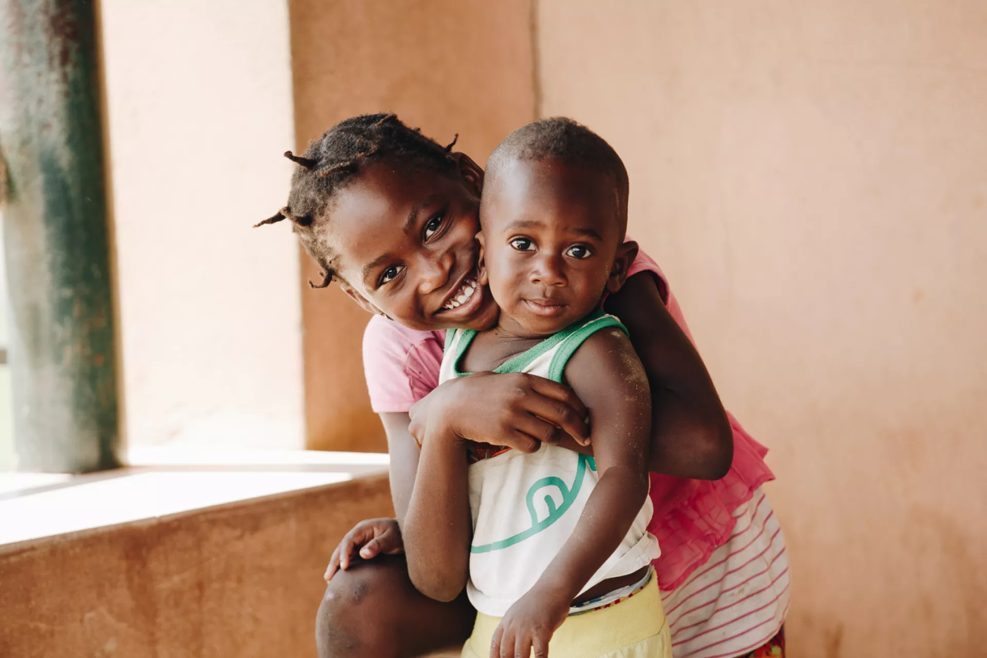 Menina abraça criança durante a campanha de vacinação em Luanda