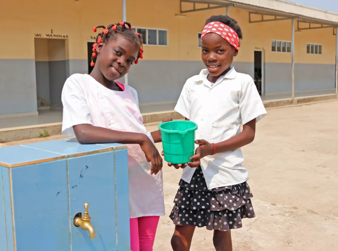 Felicidade Bernarda e Domingas Gabriel bebem &aacute;gua pot&aacute;vel na Escola 141, que faz parte das Escolas Amigas da Crian&ccedil;as em Luena, Prov&iacute;ncia do Moxico.