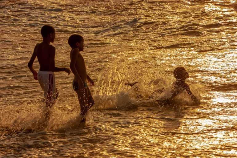 Meninos brincam na praia