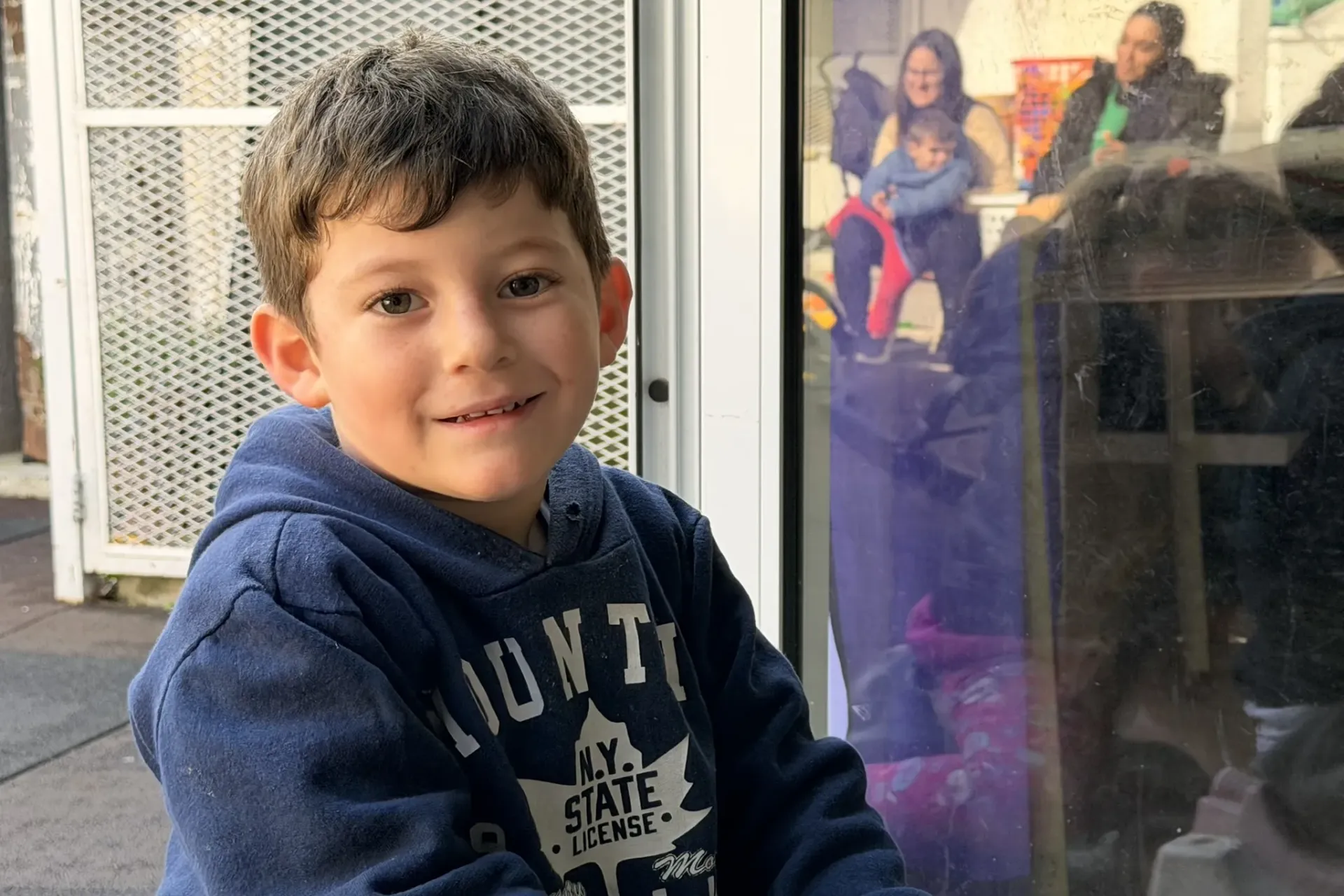 Ni&ntilde;o con abrigo azul sonriendo