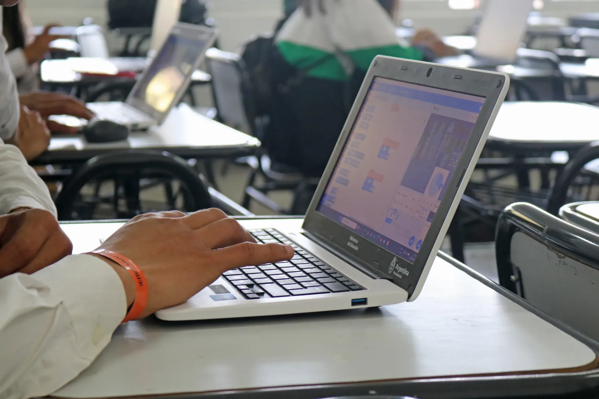 Un joven realizando sus tareas en clase en una computadora