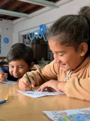 Ni&ntilde;a y ni&ntilde;o sonriendo haciendo dibujos