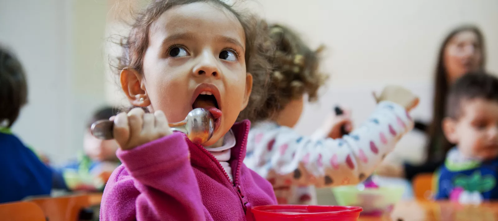 Una ni&ntilde;a come de un pote en un jard&iacute;n maternal