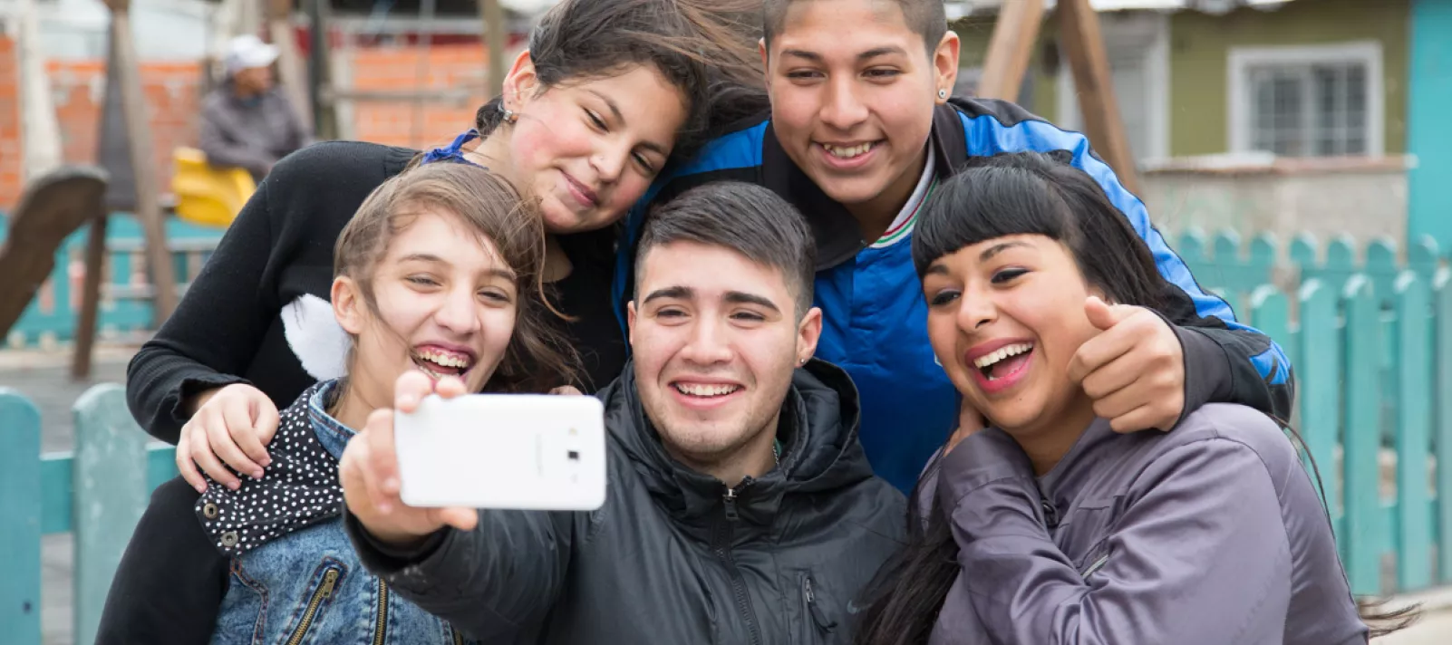 Un grupo de adolescentes sonr&iacute;e mientras se sacan una selfie con un celular