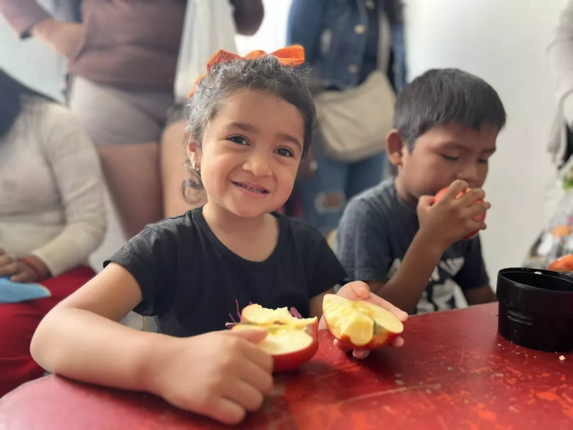 Una nena come una manzana en el espacio L&uacute;dico &ldquo;Conce&rdquo;, en el barrio Alto Comedero, un barrio en las afueras de San Salvador. 