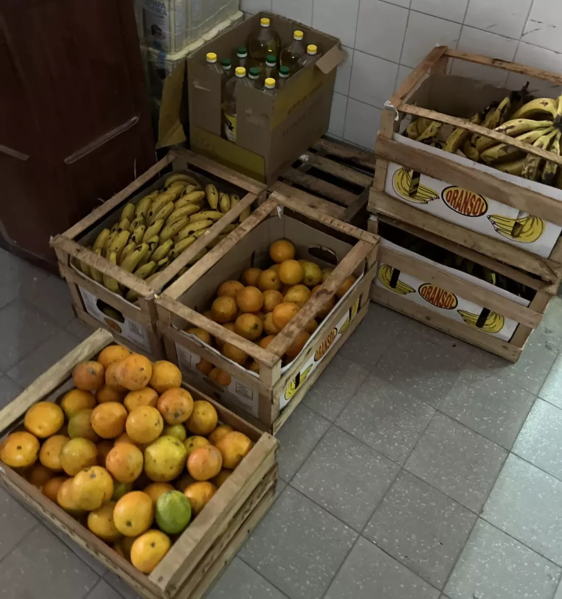Cajones de bananas y naranjas del puesto de recuperaci&oacute;n de frutas y verduras en el mercado local.