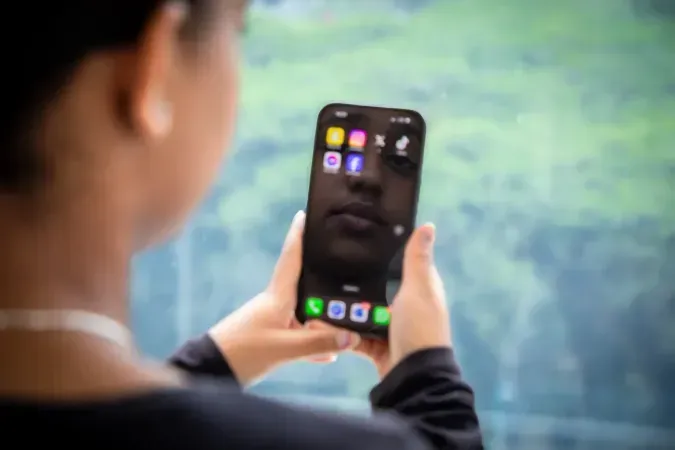 Una adolescente mira la pantalla de su celular