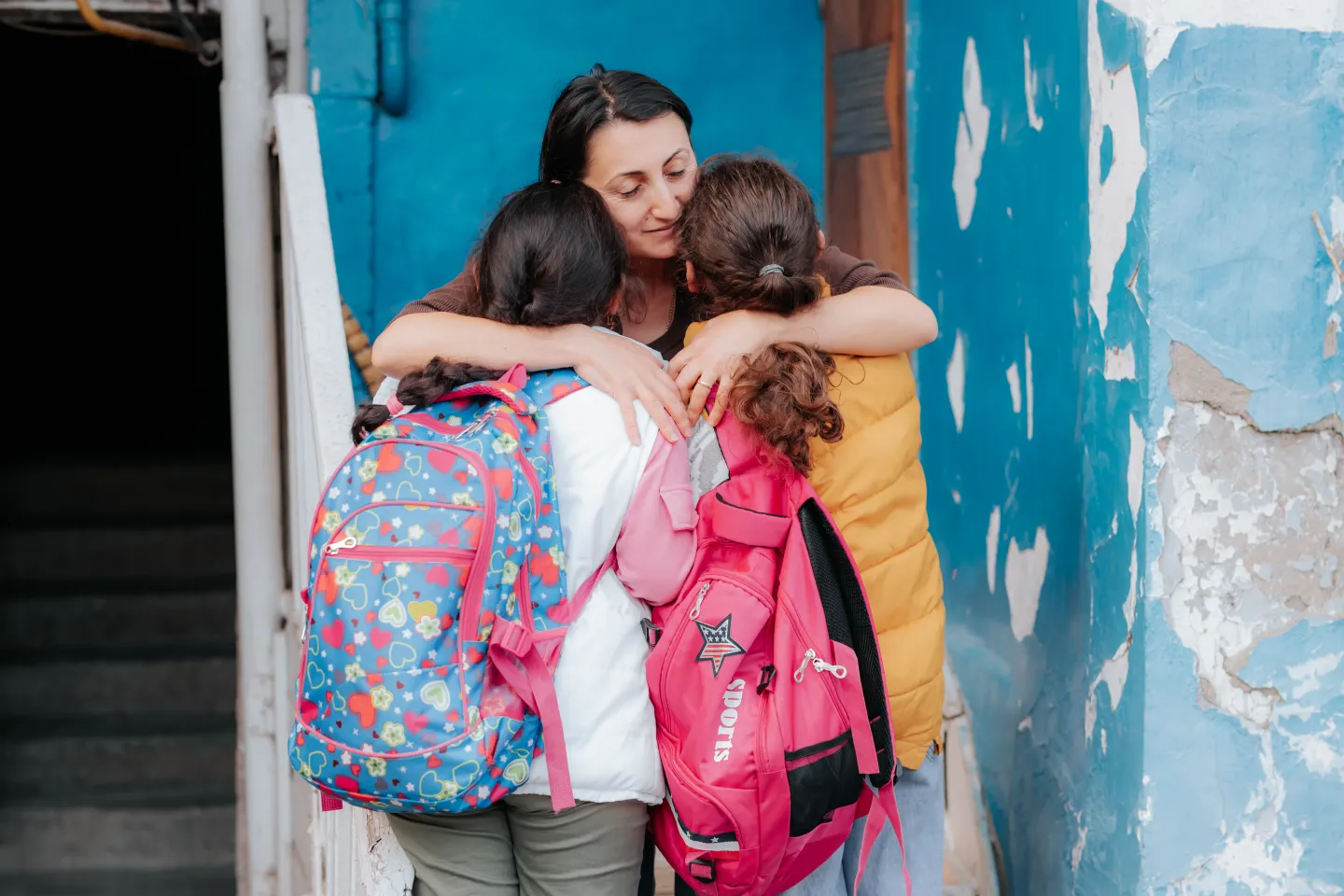 Mother is hugging her children.