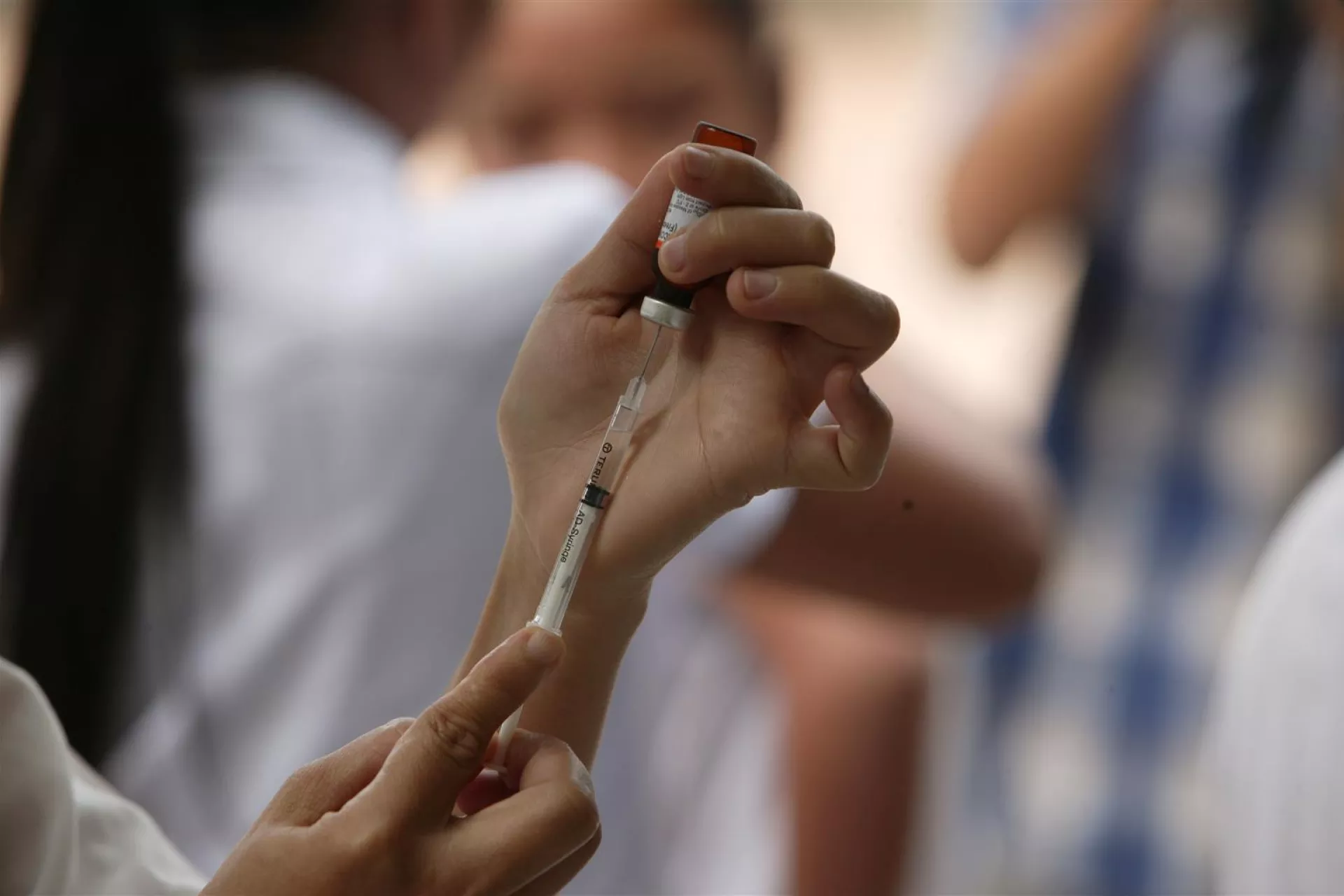 Nurse holding disposable vaccine syringe