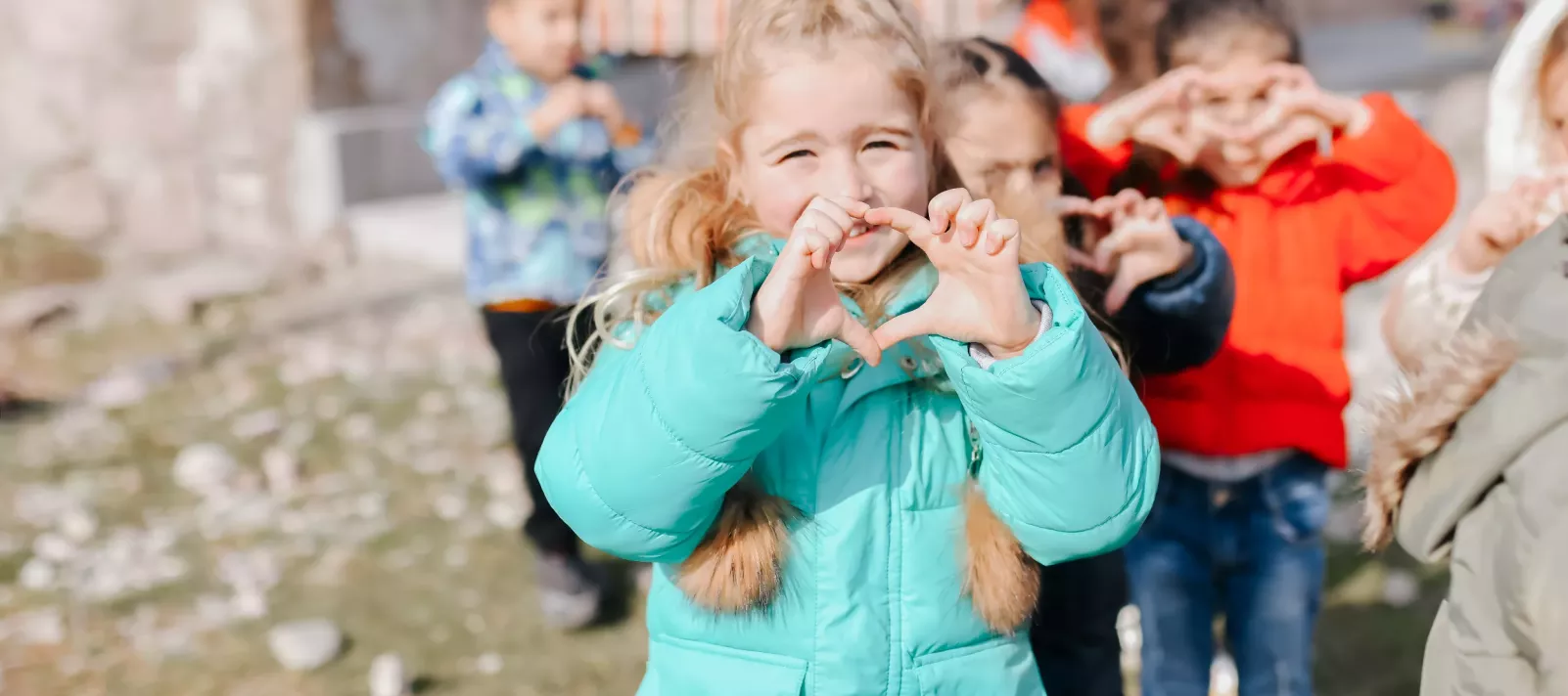 A girl is showing heart with her hands. 