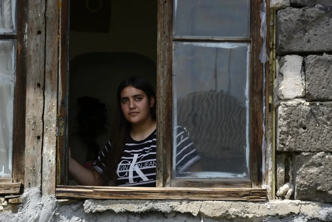 Պատուհանից դուրս նայող դեռահաս աղջիկ