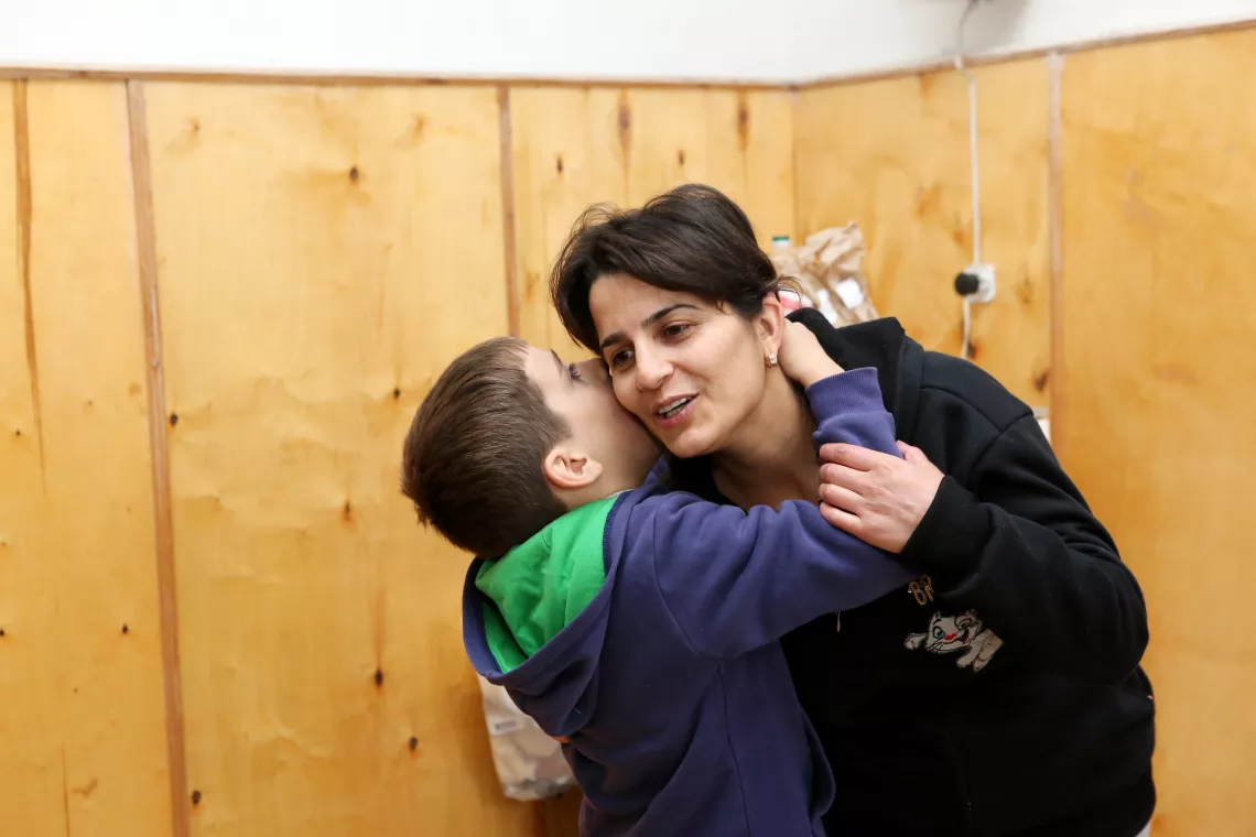 A young boy hugging and kissing his mother