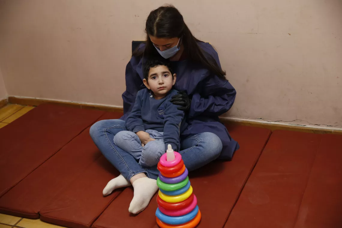 Robert and his mother are sitting on the floor of the Source Centre. 