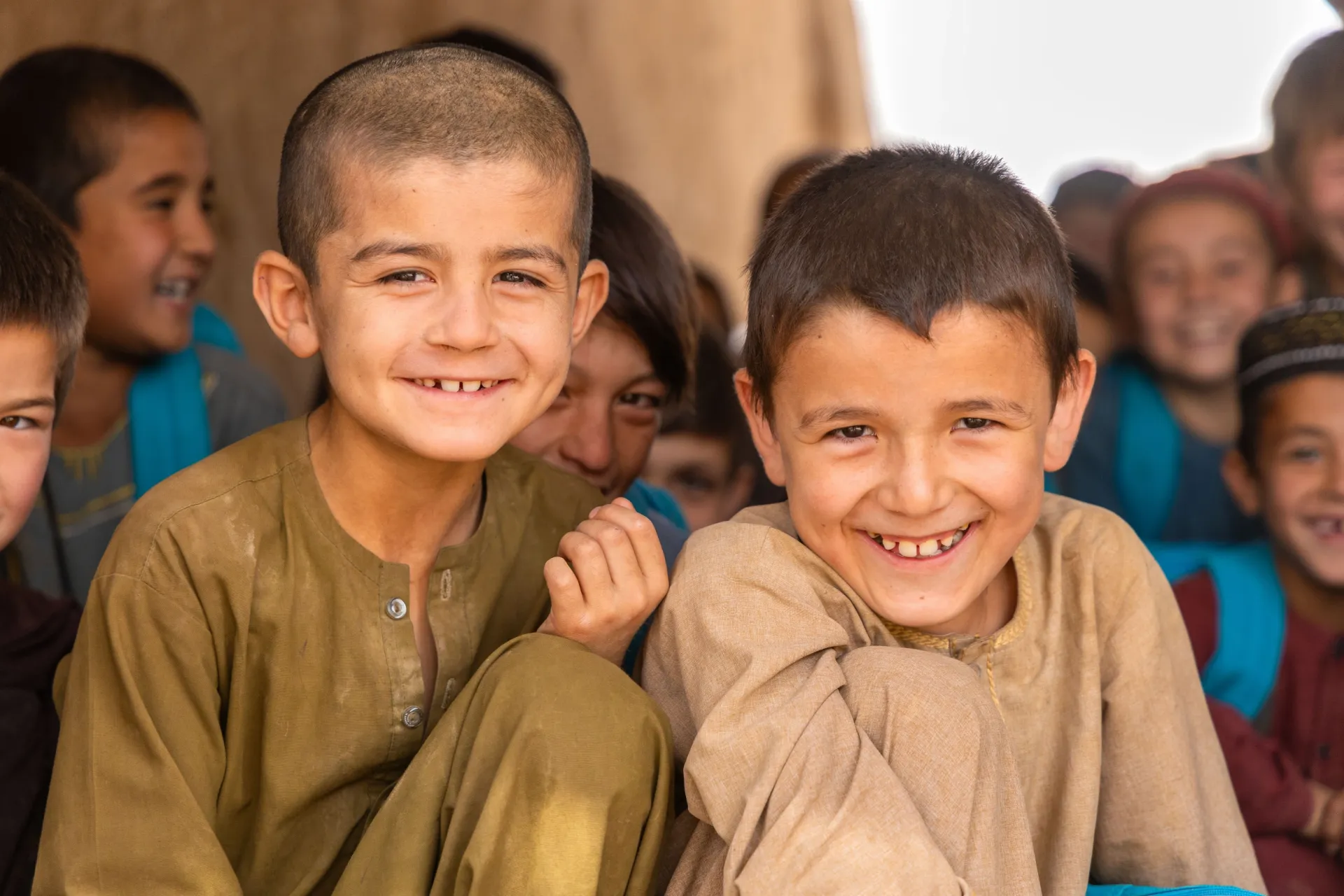 two young boys smile at the camera