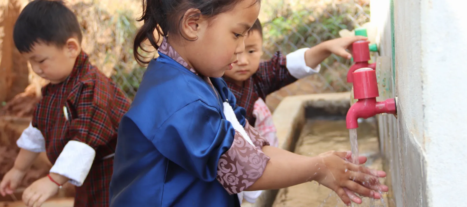child washing her hands at a handwashing station