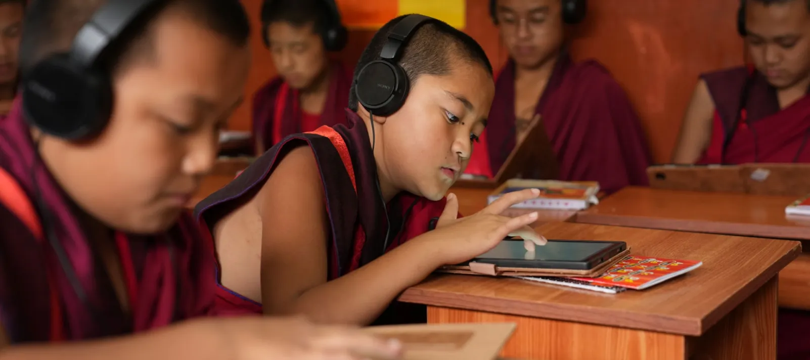 Students working on tablets in a classroom.