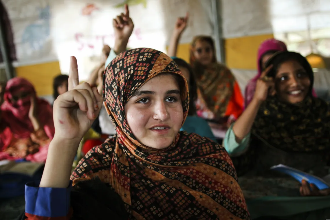 Zainab Jan (12) raises hand to answer the question asked by the teacher during her class in UNICEF-supported camp schools.