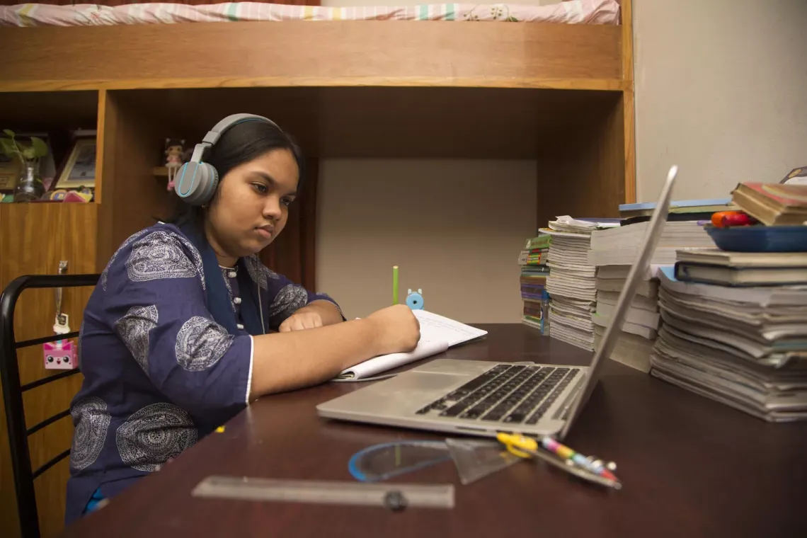 An eight-grader participates in online classes organized by her school. 