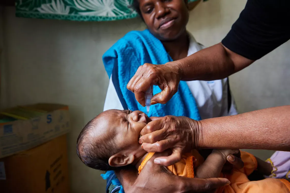  three-month-old Cornellia is held by her mother, Benalyn, 32, while being vaccinated in Lae, Papua New Guinea.