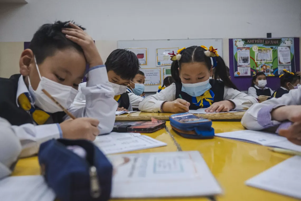 Children wearing face masks inside a classroom at School 151, which is heated by coal. 