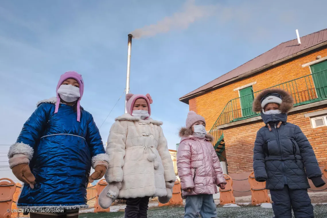 Children playing in the playground of their kindergarten in Nalaikh, Mongolia. Due to poor outdoor air quality caused by coal usage for heating during the harsh Mongolian winters, they must wear face masks. Their kindergarten also relies on coal for heating.