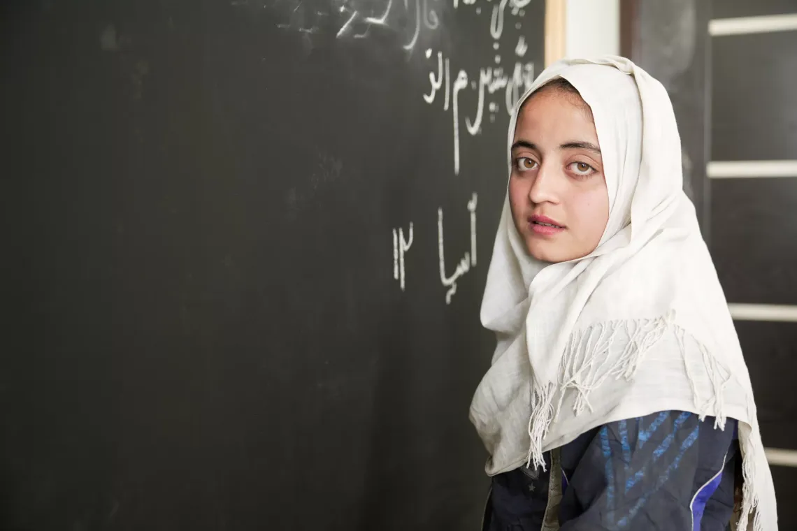 A girl stands at a blackboard