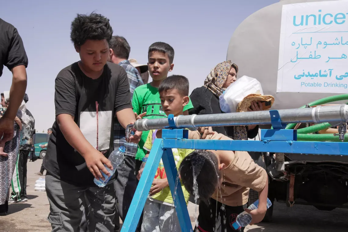 On 28 June, a boy fills a water bottle with safe drinking water form a UNICEF provided water point at the Islam-Qala border, near Herat in western Afghanistan. 
