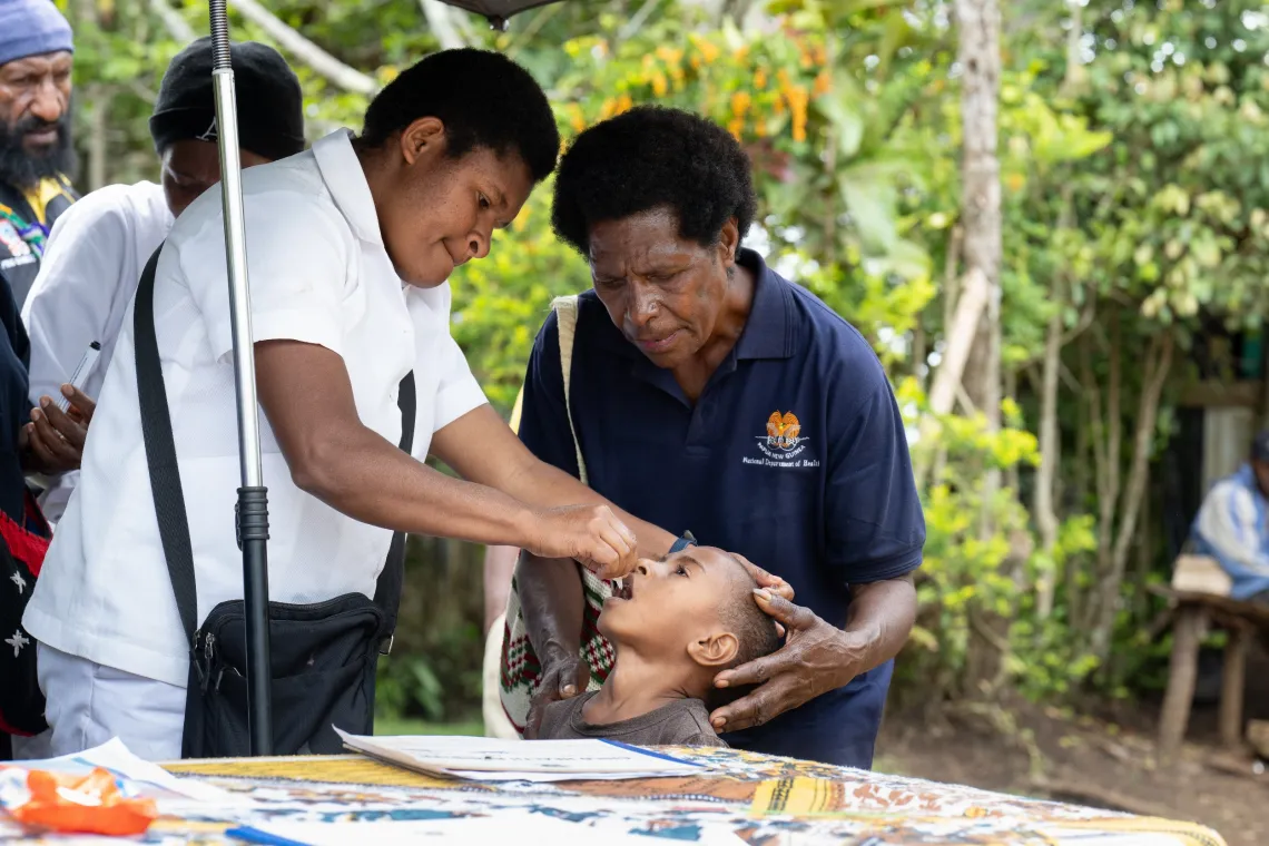 A health worker gives an oral dose of polio vaccine to a young child