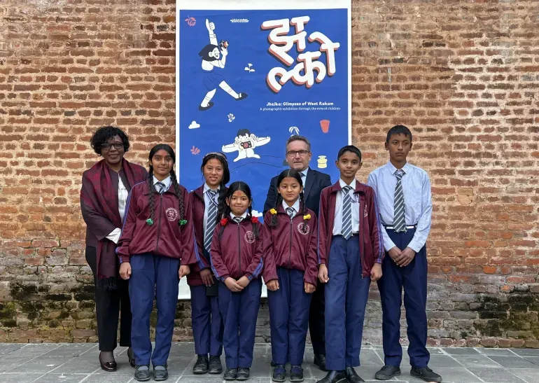 Students post in front of the event poster.