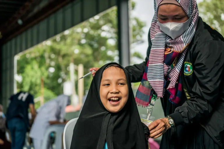 Girl smiles after she receives her vaccination.