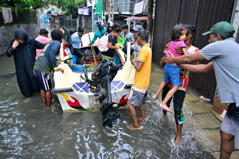 Evacuated residents moving to safety following flooding in Wellampitiya.