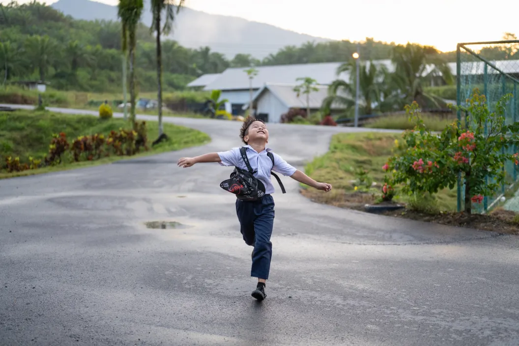 Boy running down a wet street