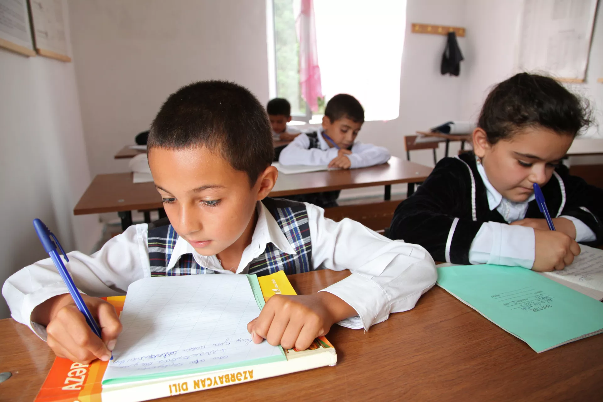 Children writing in classroom.