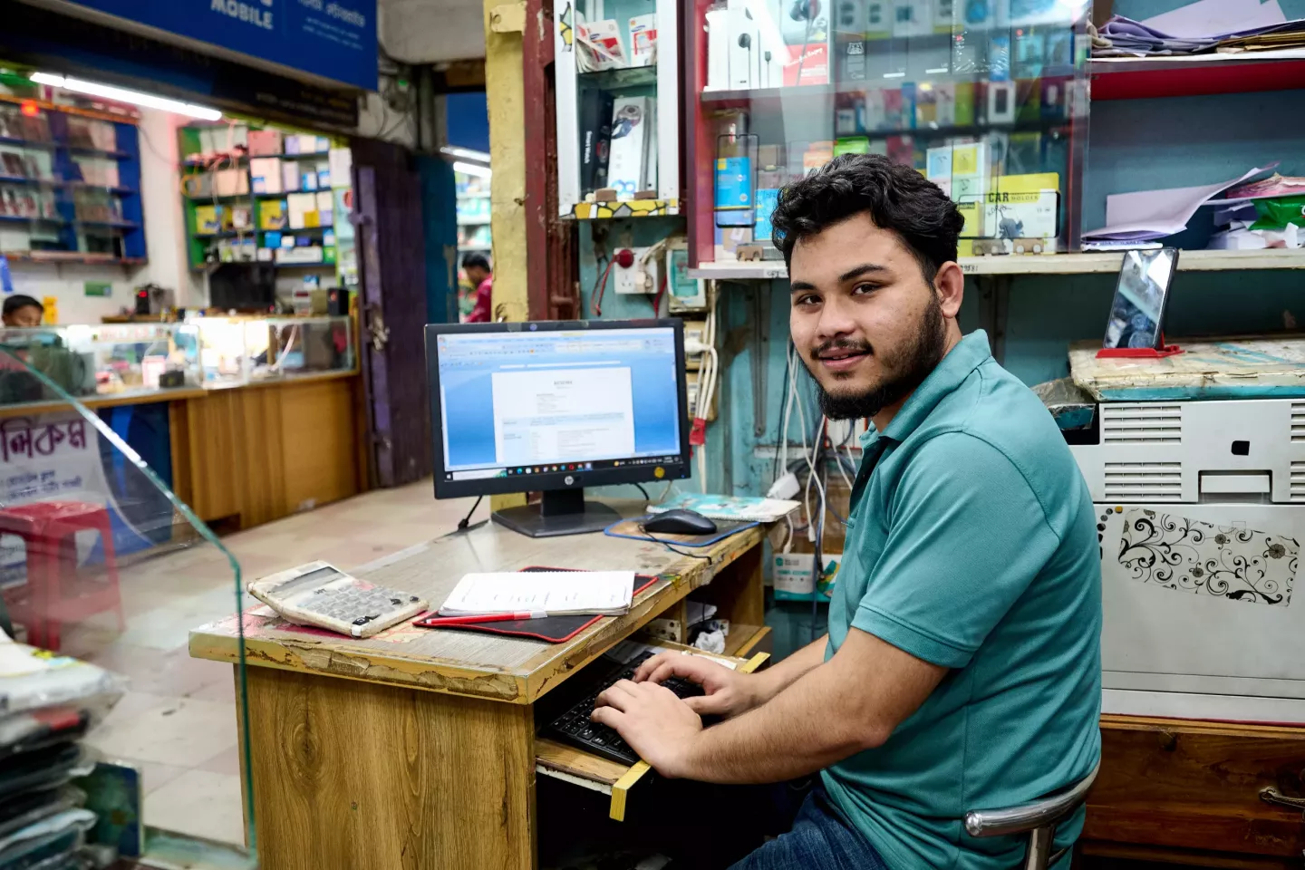 Delwar, 22, sits at his workspace in an electronics shop in Cox&rsquo;s Bazar, Bangladesh. 