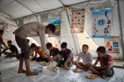 Hasib at a UNICEF Child Protection Service Hub, practising his school work, resting and eating a healthy meal. At the hubs, children also receive counselling, and have the opportunity to play and learn with other children.