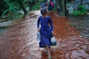 Smritee helps her mother carry drinking water from outside.