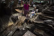 Taslima with her daughter, Mim, standing in front of what used to be her house, now nothing more than a pile of ashes and ruins
