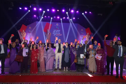 Guests and attendees raise their red cards on the stage at today's 'National Multimedia Campaign on Prevention of Violence Against Children (VAC) and Child Marriage (CM)' launch event.