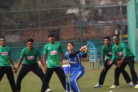 Bangladesh. A girl is playing cricket.