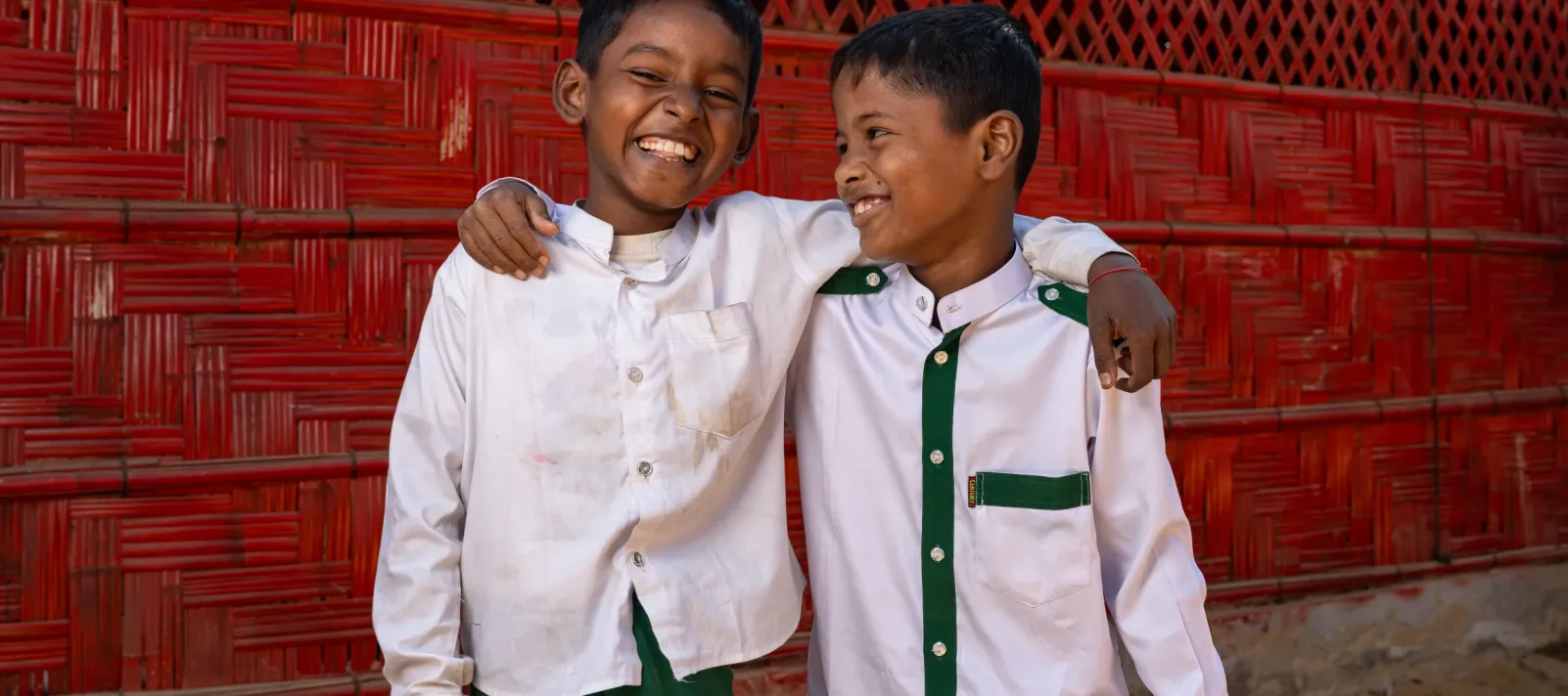 Photo of two best friends hugging each other in front of a learning centre.