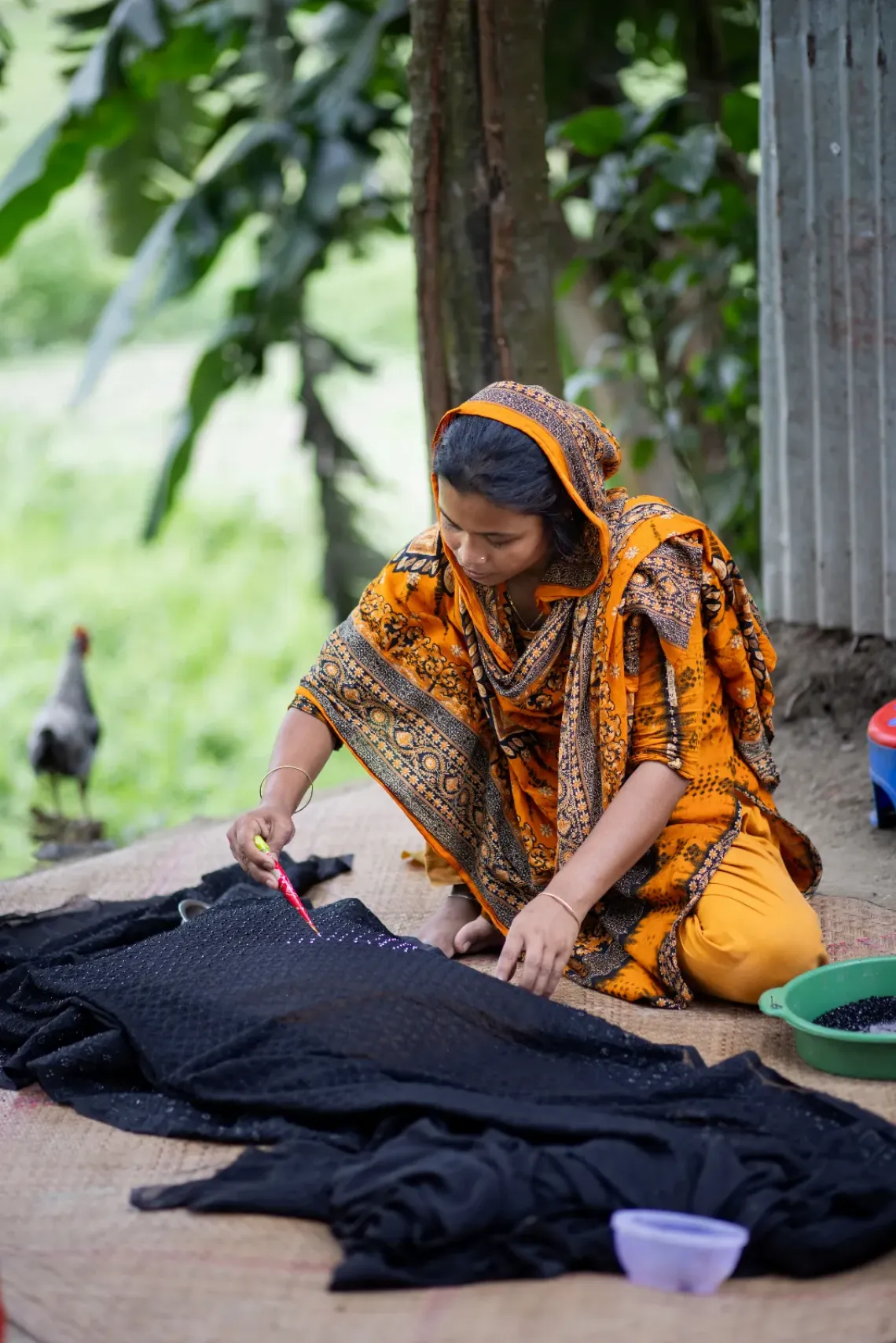 Shefali works on embroidery, one of several livelihoods she balances alongside farming, tutoring and caring full-time for her children. 