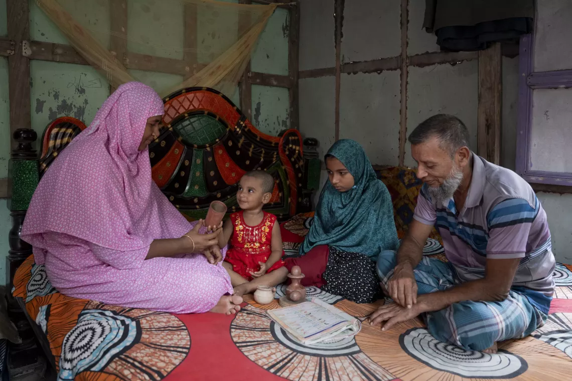 At home, Fahima and Mohiuddin play with their daughters Maha and Roza, using toys, and picture books.  